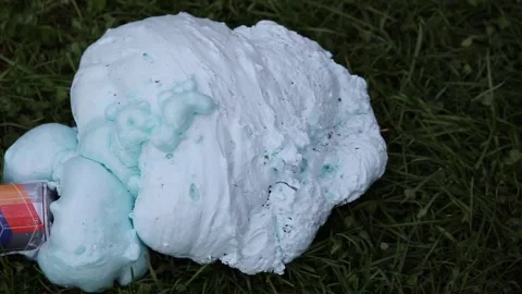 An exploded cylinder with construction foam on the grass. Balloon defect, close Stock Footage 165744004