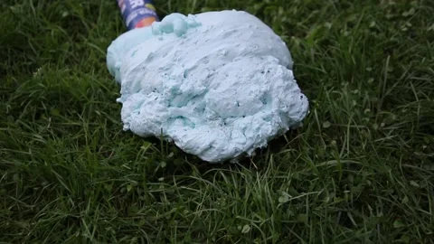 An exploded cylinder with construction foam on the grass. Balloon defect, close Stock Footage 165744034