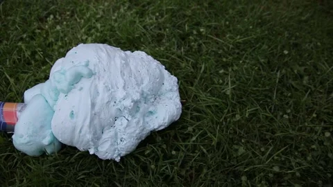 An exploded cylinder with construction foam on the grass. Balloon defect, close Stock Footage 166046455