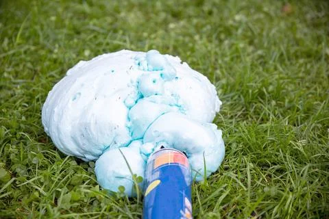 An exploded cylinder with construction foam on the grass. Balloon defect, close Photos