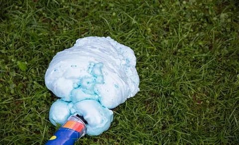 An exploded cylinder with construction foam on the grass. Balloon defect, close Photos