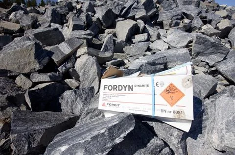 Exploded rocks and Fordyn cardboard dynamite box at rock quarry, Finland Stock Photos