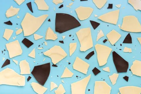 Exploded white and dark chocolate Easter eggs over blue background, holiday c 스톡 사진