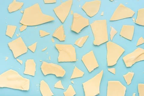 Exploded white chocolate Easter eggs over blue background, holiday concept 스톡 사진