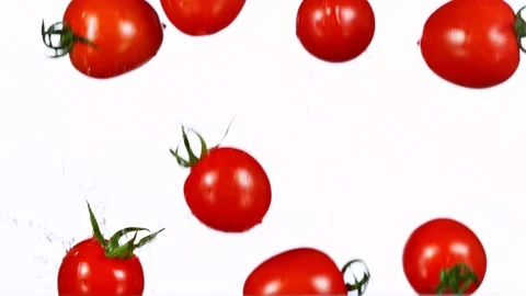 Exploding cherry tomatoes with water on a black background. Stock Footage 149974604