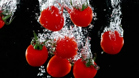 Exploding cherry tomatoes with water on a black background. Stock Footage 150806616