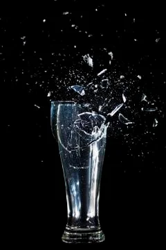Exploding Glass cup shattering over black background. Foto stock