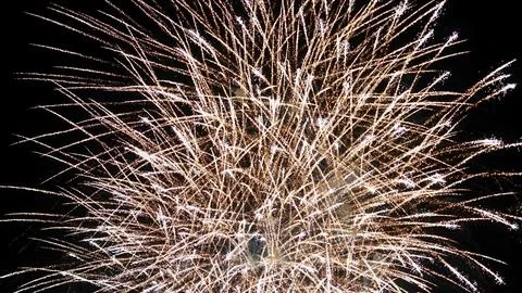 Exploding golden fireworks display against a dark night sky Stock Photos