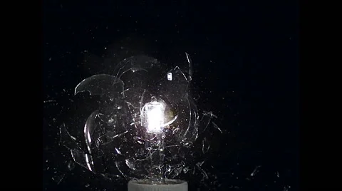 Exploding light bulb  against black background, slow motion Stock Footage
