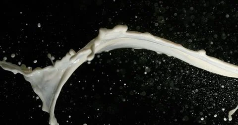 Exploding Milk against Black Background Stock Photos