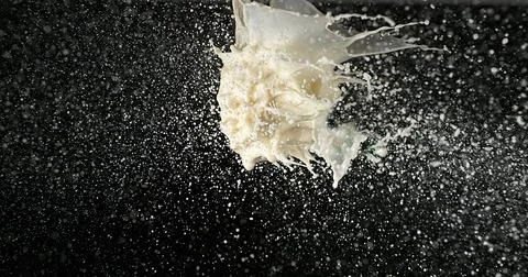 Exploding Milk against Black Background Stock Photos