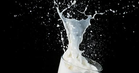 Exploding Milk against Black Background Stock Photos