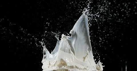 Exploding Milk against Black Background Stockfoto's
