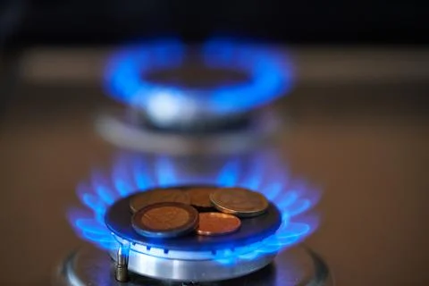 Exploding natural gas prices. Expensive Gas. Euro coins on gas stove Stock Photos