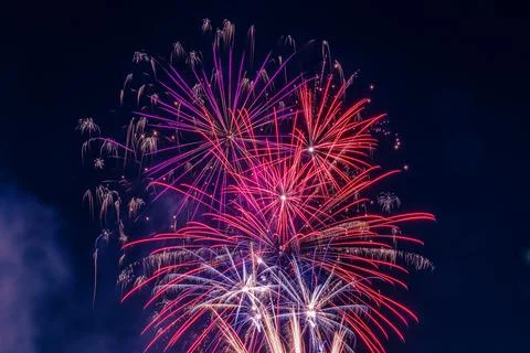 Exploding Red, Pink and Purple Fireworks at Night At Festival Stock Photos