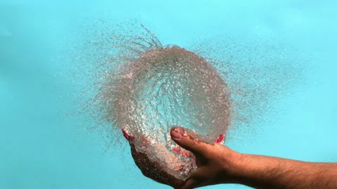 Exploding of Red Water Balloon in a Palm Bursting with Drops on a Blue 動画素材 154549453