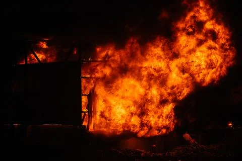 Exploding warehouse. Burning industrial building. Big blaze at night Foto stock