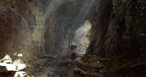 Exploration of a breathtaking cave with sunlight filtering through the entran Stock Illustration