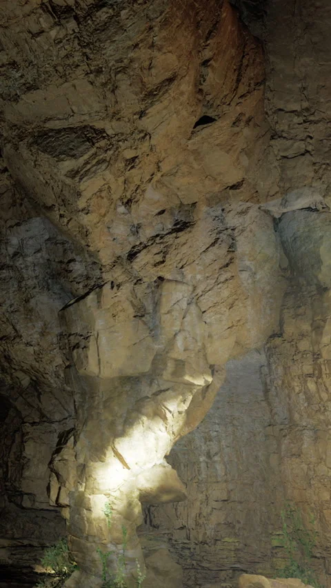 Exploration of rock formations in a dark cave during evening hours Stock Footage 331449030