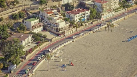 Explore Benidorm beaches with sun, sand, and local buildings on a warm day as pe Stock Footage 337151934