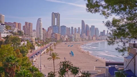 Explore Benidorm's beautiful beach and skyline at sunset with people enjoying th Stock Footage 337151943