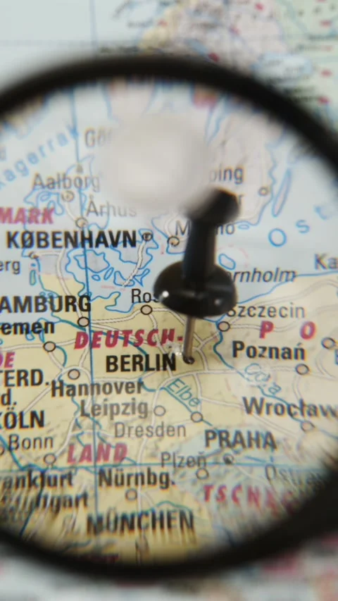 Explore Berlin on a printed map with a magnifying glass Stock Footage 342435511