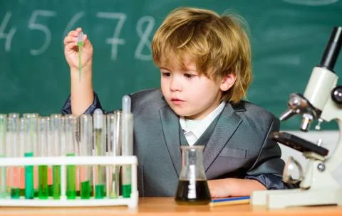 Explore biological molecules. Toddler genius baby. Boy near microscope and test Stock Photos