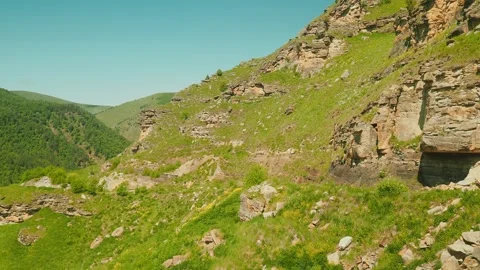 Explore a breathtaking rocky terrain adorned with vibrant greenery, showcasing Video stock 312518820