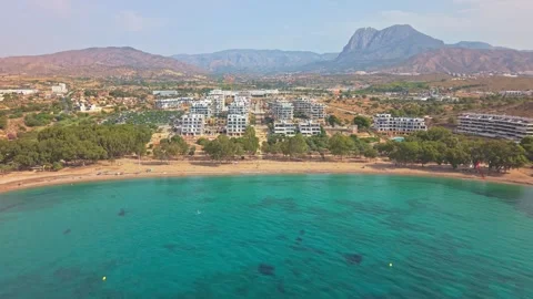 Explore a coastal area with buildings, beach, and mountains during sunny we.. Stock Footage 340191978