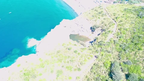 Explore a Coastal Area With Rock Formations and Clear Water Near a Green Stock Footage 322933823