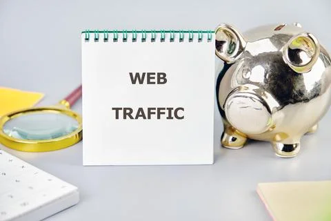 Explore the concept of web traffic management through a notepad and piggy ban Stock Photos