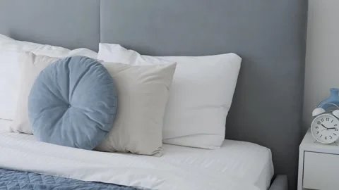 Explore the cozy bedroom interior with a focus on the bed. Detailed view of the Stock Footage 274133702