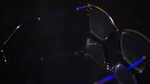 Explore the details of glasses on a dark surface with reflections and different Stock Footage 324839246