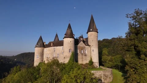 Explore the enchanting Veves Castle surrounded by lush greenery and blue skies Stock Footage 295145923