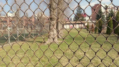 Explore the expansive view that lies beyond the chain link fence in a beautiful Stock Footage 305268588