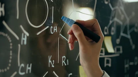 Explore, an experienced scientist writes on a glass board In the room for ex Vídeo Stock 242993460