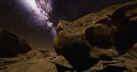 Explore the majestic night sky over rocky terrain in a remote location Ilustração Stock