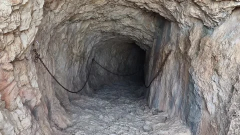 Explore the Mysterious Underground Tunnel that features Rocky Walls and flowing Video stock 317350953