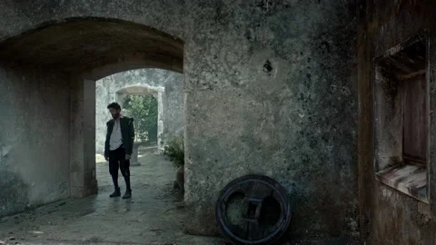 Explore an old structure while walking through an archway at sunset Stock Footage 327966183