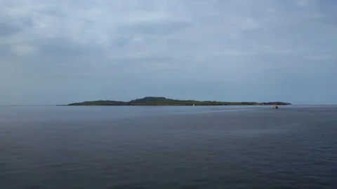 Explore a remote island during cloudy afternoon on the water Stock Footage 325930069