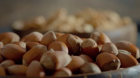 Explore the rich textures of hazelnuts and walnuts in a cozy kitchen setting Stock Footage 327582174