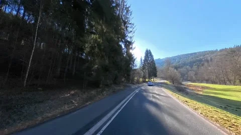 Explore a Scenic Highway Landscape filled with Lush Trees under a Clear Blue Sky Stock Footage 303831160