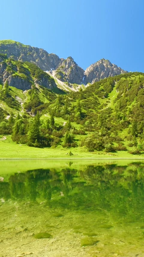 Explore Spring in the Bavarian Alps: Beautiful Views of Geisalpsee with Lush Stock Footage 309230332