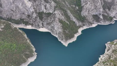 Explore the stunning aerial view of Piva Lake surrounded by majestic mountains Video stock 287789097
