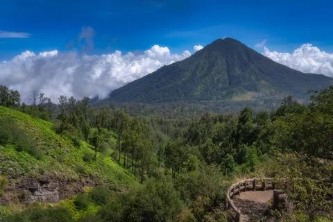 Explore the stunning landscape featuring a volcano, dense forests, and a dram 스톡 사진