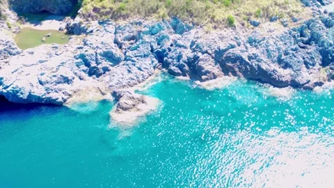 Explore the Stunning Turquoise Waters and Rocky Coastline of a Serene Seaside 動画素材 318387437