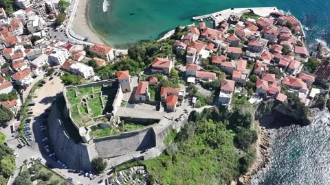 Explore the stunning waterfront view of a medieval fortress and coastal village Stock Footage 287801022