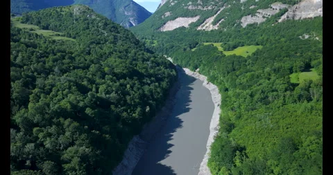 Explore the tranquil river winding through the lush green valley surrounded by Video stock 314081924