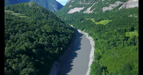 Explore the tranquil river winding through the lush green valley surrounded by 스톡 동영상 314082024