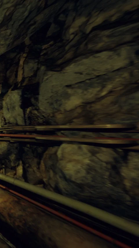 Explore underground pipes in a rocky tunnel environment during daylight hours Stock Footage 339954154